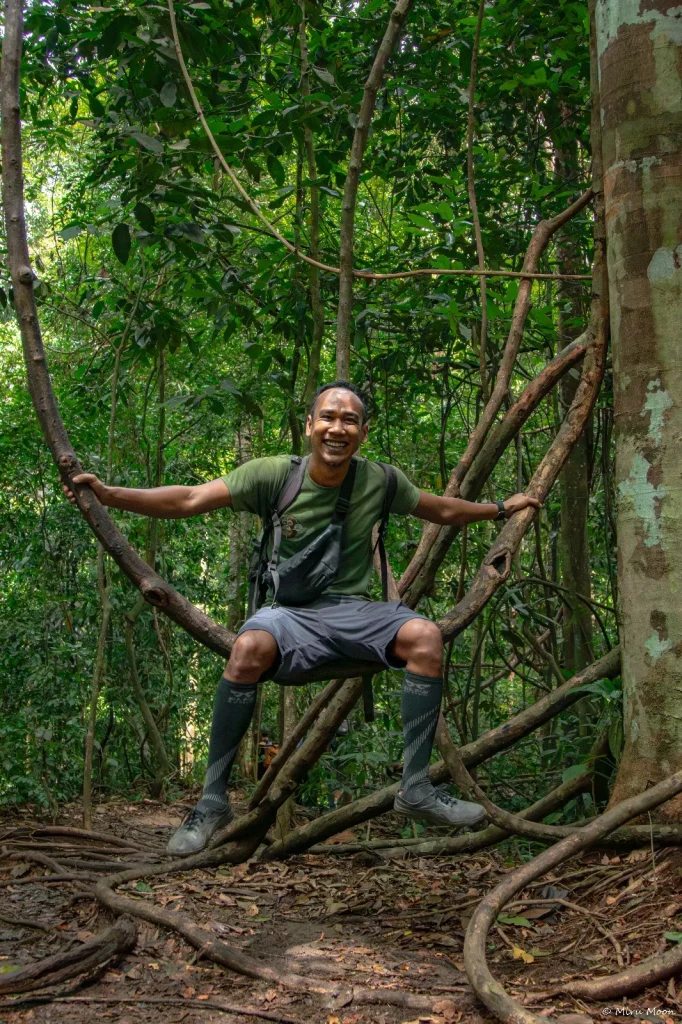 HornyBills jungle trekking guide resting in a natural seat of vines
